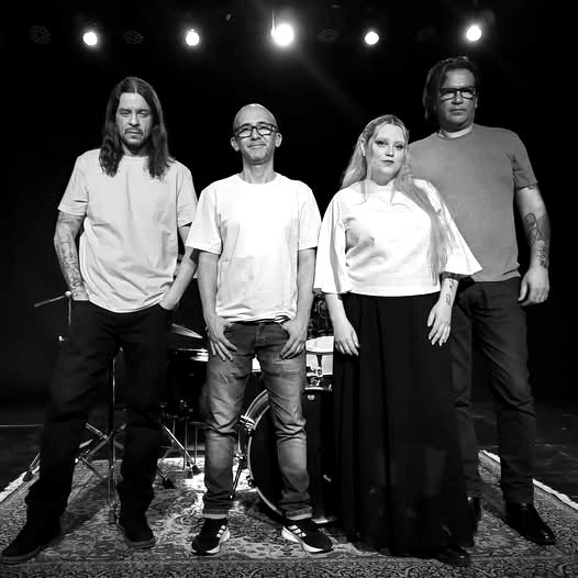 Sub Rosa, foto em preto e branco dos quatro integrantes no palco
